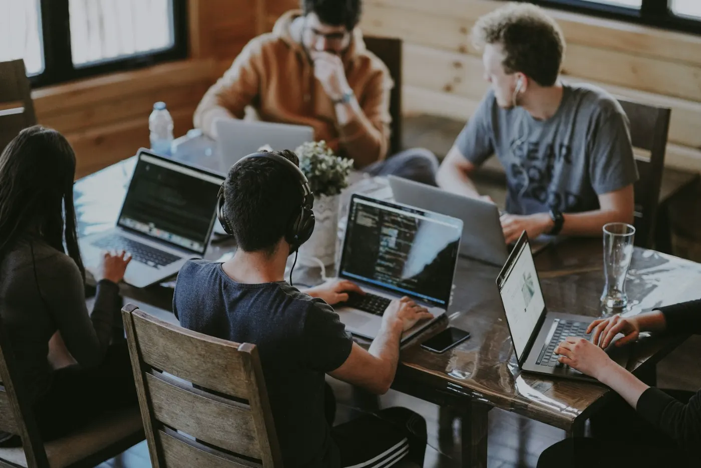 Team arbeitet an Laptops an einem gemeinsamen Tisch